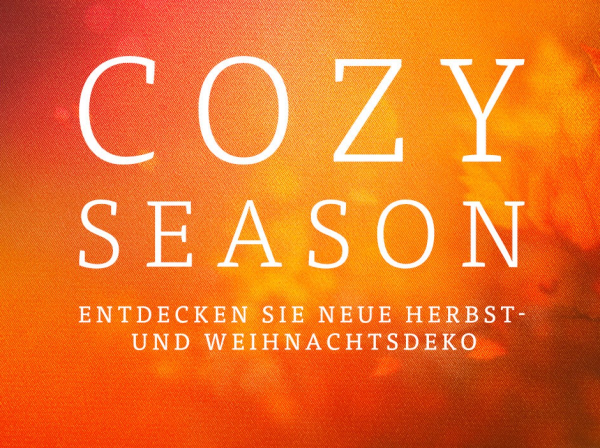 Schriftbild auf orangerotem Grund: &bdquo;Cozy Season &mdash; Entdecken Sie neue Herbst- und Weihnachtsdeko"