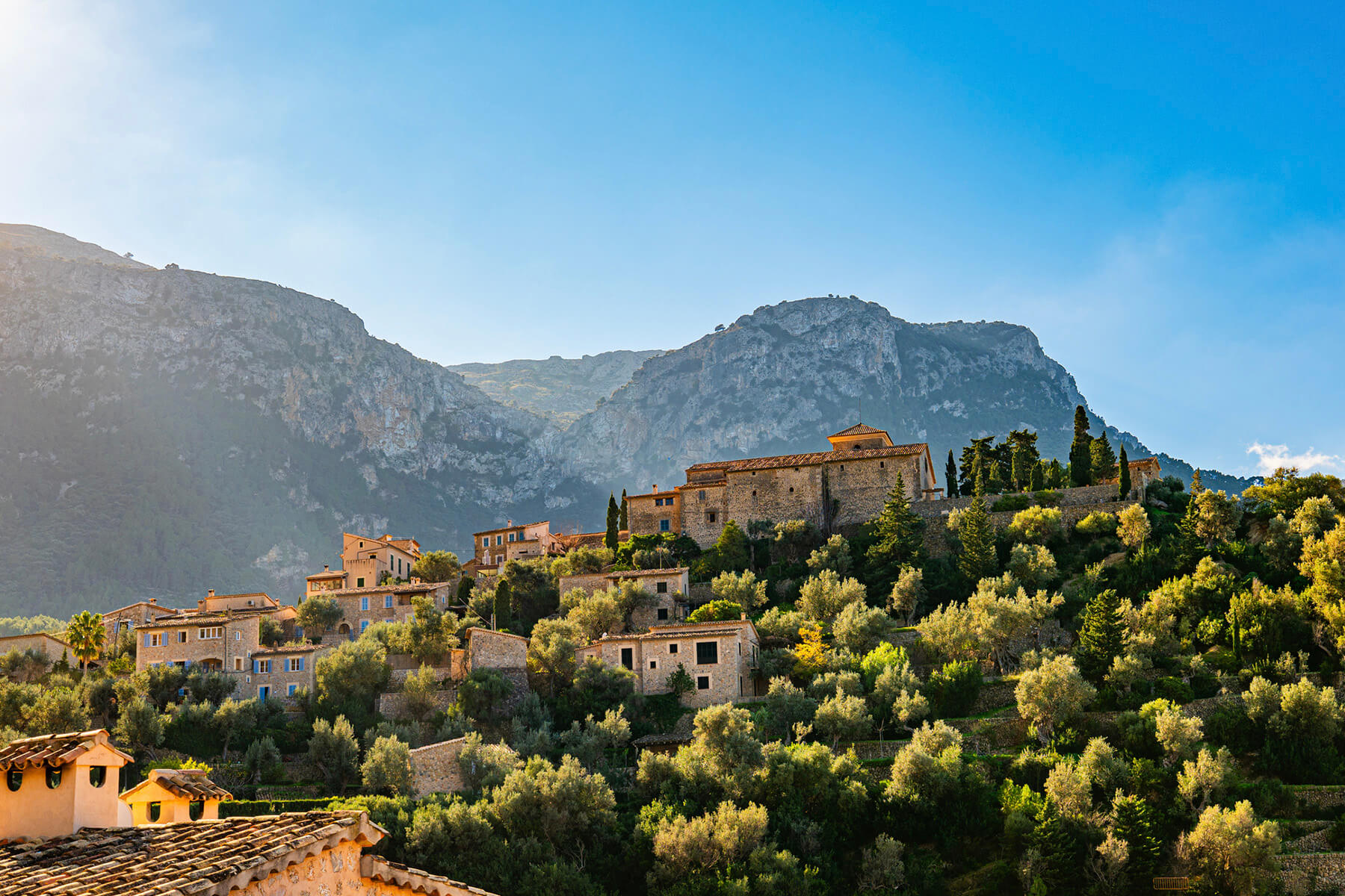Bergdorf aus Natursteinh&auml;usern an einem Hang der Serra de Tramuntana, umgeben von Olivenhainen und Terrassenmauern